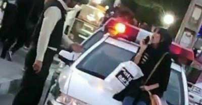 بازداشت زن جوانی که روی خودروی پلیس نشست