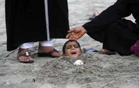 دفن کودکان توسط کشیشان در شن + عکس